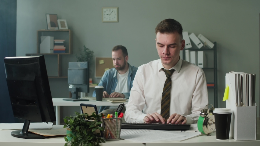 Irritated man in business uniform works in office, keypad stops working, angry employee breaking keyboard on the table, destroying everything in workplace. Bad mood, failure at work.  Royalty-Free Stock Footage #1073980175