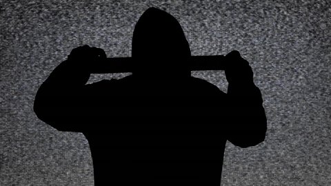 An ominous black silhouette, a man wearing a hoodie, unrolling adhesive tape, sealing the viewer's mouth and eyes. Background: static analog tv noise.
