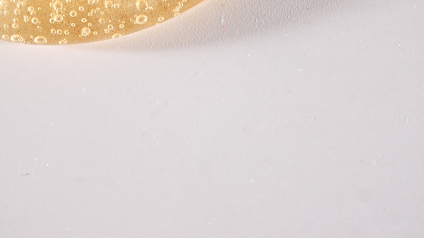 Yellow Transparent Cosmetic Gel Cream With Molecule Bubbles Flowing On The Plain White Surface. Macro Shot | Shutterstock HD Video #1073986067