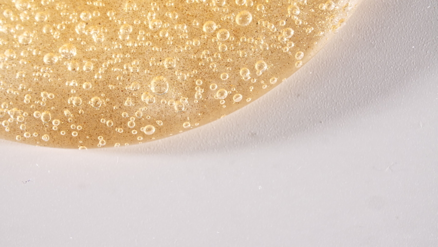 Yellow Transparent Cosmetic Gel Cream With Molecule Bubbles Flowing On The Plain White Surface. Macro Shot | Shutterstock HD Video #1073986067