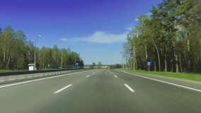 Video shooting in motion, the car is driving on a large highway road on a sunny day in summer