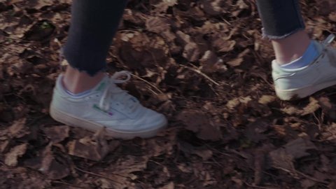 Feet of a Girl walking through leaves in a Forrest - Slowmotion