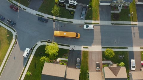 Yellow school bus. Top down birds eye aerial of kids children and students as they run and enter at bus stop. Public education transportation theme.