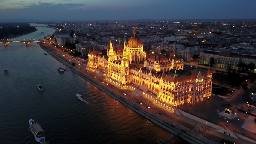 Cinematic 4K aerial drone night dolly clip of the illuminated Hungarian Parliament Building with the Danube river, bridges lit up after sunset in Budapest, Hungary Royalty-Free Stock Footage #1073995559