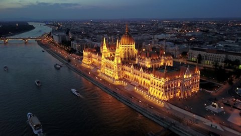 Cinematic 4K aerial drone night dolly clip of the illuminated Hungarian Parliament Building with the Danube river, bridges lit up after sunset in Budapest, Hungary
