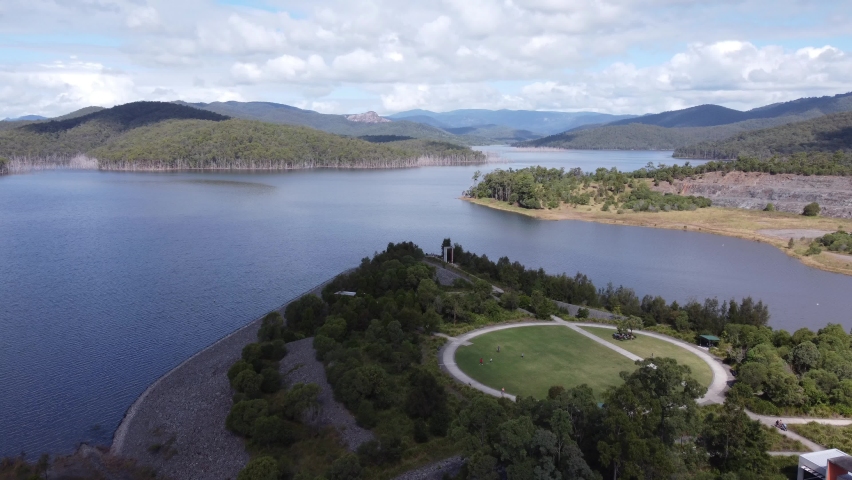 Flying over a green field and to over water on a lake