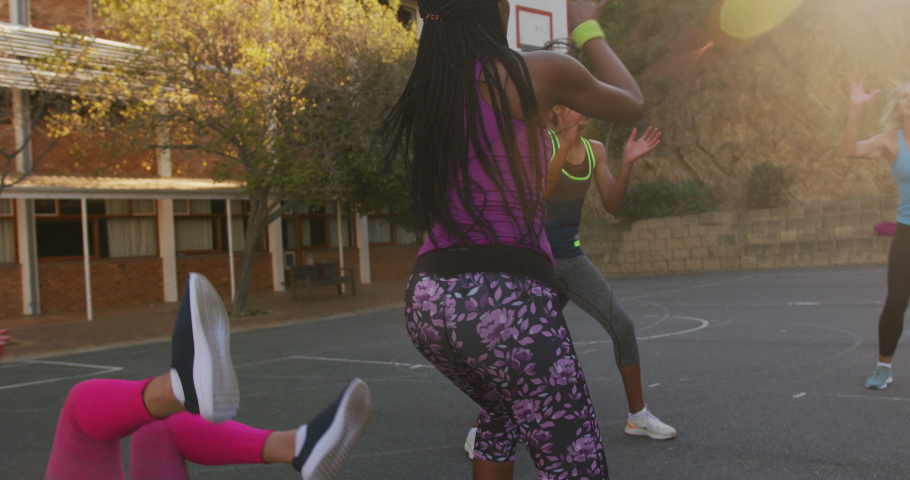 Diverse female basketball team playing match, helping each other. basketball, sports training at an outdoor urban court. Royalty-Free Stock Footage #1074002552