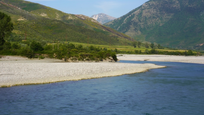 Beautiful river landscape with valley and mountains background in lush vegetation, Vjosa in Albania