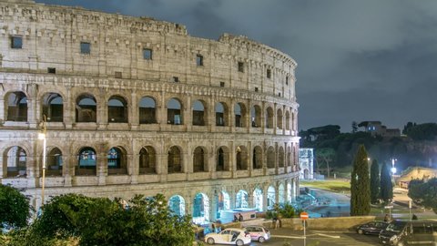 Colosseum illuminated at night timelapse in Rome, Italy. Top view. Traffic on the road