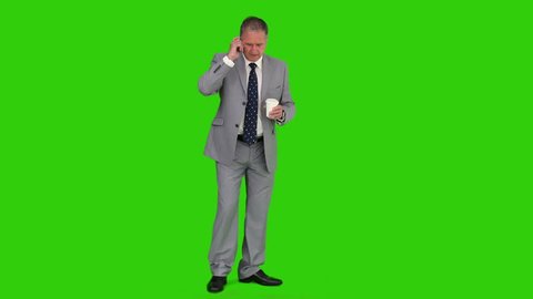 Chromakey footage of a mature businessman in suit having a phone call