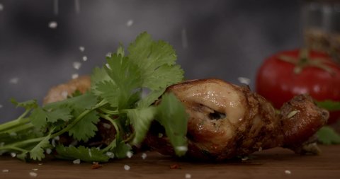 Hot and fried chicken leg, appetizing and delicious chicken in a skillet on gey background. Slow motion footage, 6K downscale, studio shoot. 4K.