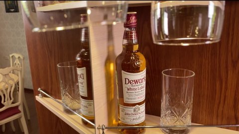 Bottle of dewar’s white label on shelf in bar, brown background with reflection. Scottish cognac. Perm, RUSSIA, 10 June 2021.