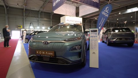 PRAGUE, CZECH REPUBLIC - AUGUST 28, 2020: Front view of a green Hyundai Kona at a car exhibition, a gray car in the background, people walk in the background