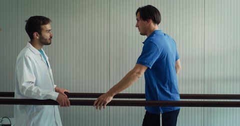 
Cinematic shot of isometric doctor physiotherapist helps to patient with disability with artificial latest innovative futuristic technology bionic leg prosthesis to take first steps in modern clinic