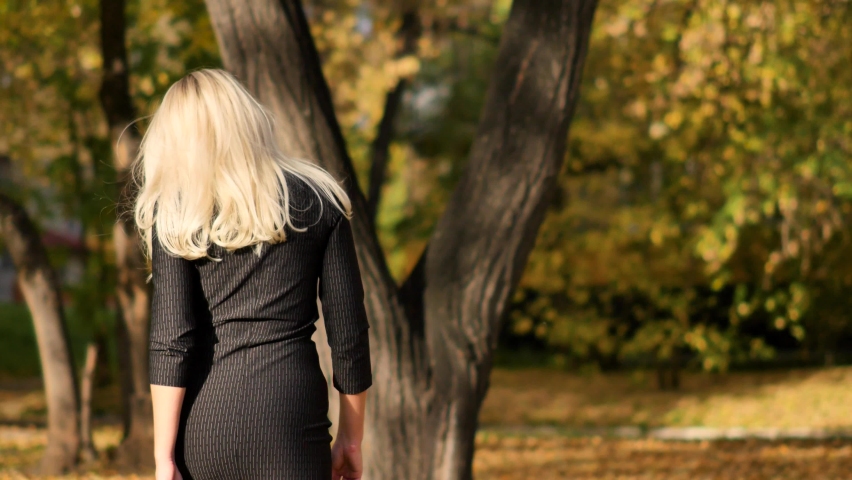 Portrait of a young beautiful woman enjoying autumn in the park