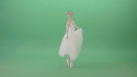Ballerina in elegant white wedding dress spinning in dance. Young and tender women solo performing classic ballet dance. Beautiful young girl wearing white wedding dress isolated on green background.
