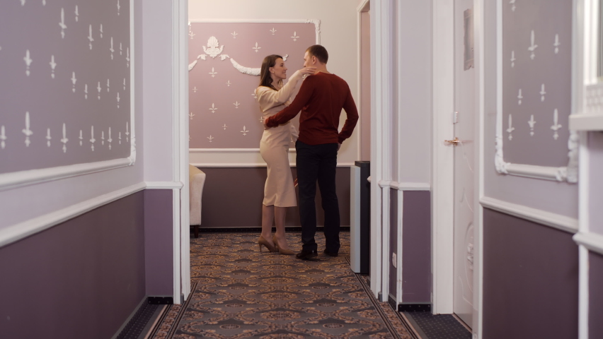 Elegant happy young couple kissing in corridor