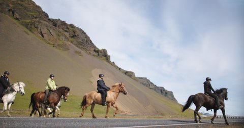 Reykjavik , Iceland - 07 06 2019: Group of people riding horses and crossing road, Iceland