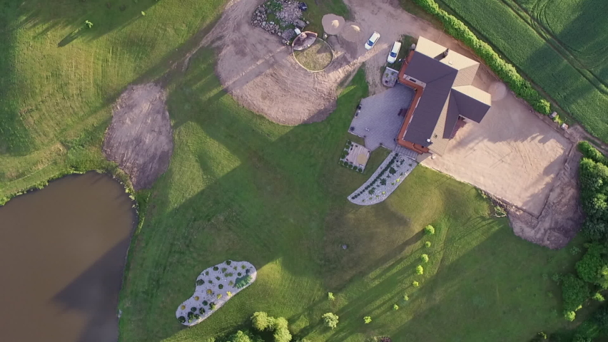 Aerial 360 view of a house surrounded by fields and a pond