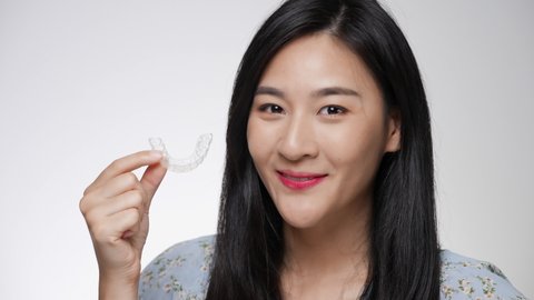 Woman wearing orthodontic silicone invisalign trainer. Mobile orthodontic appliance for dental correction. tooth whitening systems.