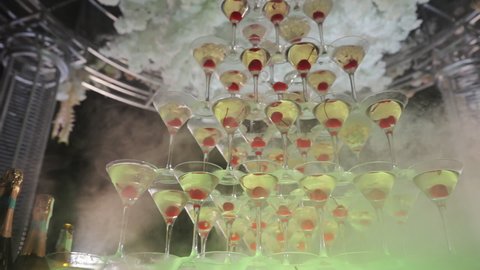 Glasses with alcohol and different drinks. Champagne tower at party celebrating with friends enjoying crazy nightlife. Catering service