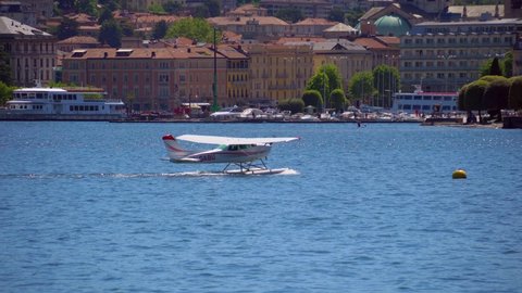 Seaplane. Ultralight aviation in Europe. Lake. Hobbies and sports. Tourism. Paroplane. Hydroplane. Airplane in the air and on the water. ITALY, Como, June 2021 