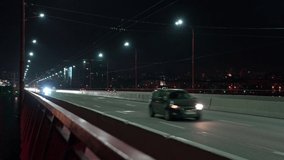 Fast traffic on a bridge with cold light across the dnieper river in the big night bright city of Dnepropetrovsk in wonderful Ukraine. UHD 4K speed up video