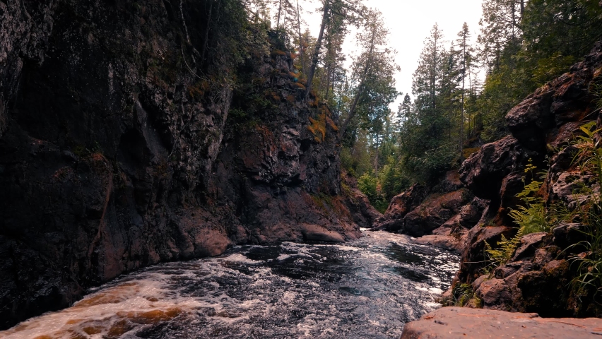 Cascading river flowing through rocky gorge in the woods at Cascade River State Park in Minnesota