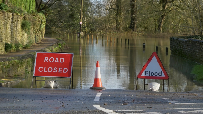 Long Shot of Road Closed and Flood Signs In Front of Flooded Street. Royalty-Free Stock Footage #1074092288