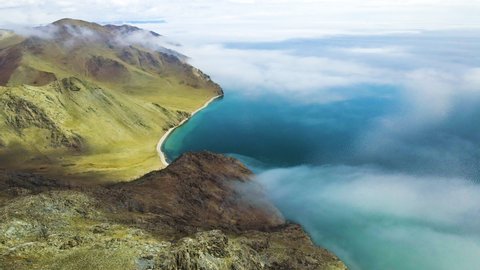 Beautiful shore of Baikal lake with clear blue water. Clouds over the lake and mountains in misty morning. Aerial drone view. Baikal lake, Siberia, Russia. Beautiful spring landscape. 