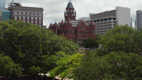 Aerial view of building in historic castle style with tower and few turrets. Old Red Museum of Dallas County between modern multi-storey office blocks downtown. Dallas, Texas, US