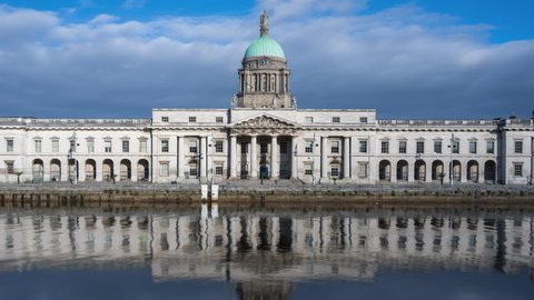 Time lapse of Custom House historical building in Dublin City during daytime with reflection on Liffey river in Ireland. 
