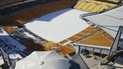 Pittsburgh , Pennsylvania , United States - 02 04 2021: Drone overflight above Heinz Field football stadium in Pittsburgh, Pennsylvania. The field is cover in snow.