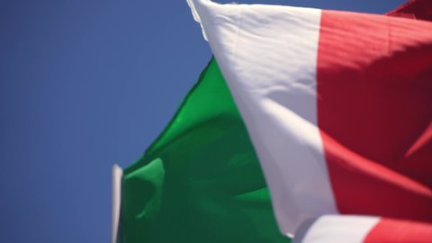 Macro shot closeup of an Italian green white and red flag swinging in the wind. National symbol.