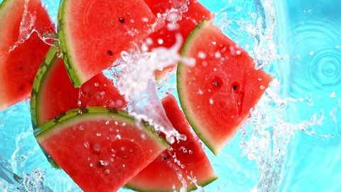 Super Slow Motion Shot of Falling Fresh Watermelon Slices into Water.