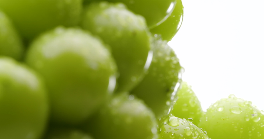 Close-up video of Muscat grapes slowly rotating on a white background.