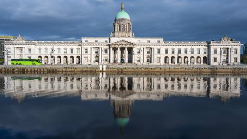 Time lapse of Custom House historical building in Dublin City during daytime with reflection on Liffey river in Ireland.