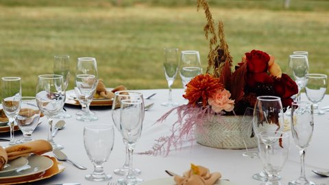 Wedding place settings and floral centerpiece at breezy outdoor reception