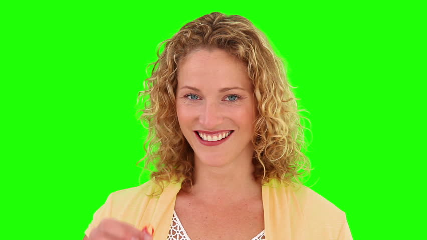 Curly-haired woman showing us the keys of her new home against a green screen
