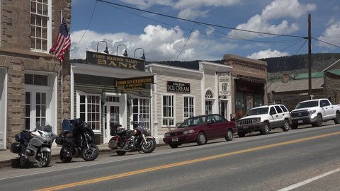 ENNIS, MONTANA - JUN 2015: Ennis Montana historic main street motorcycles traffic 4K. The rural culture extends to it's main street with craft, museum, tourist shops, saloons and stores.