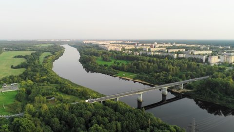 Establishing Aerial Shot of Novopolotsk Cityscape, Belarus, Europe. Main Car Bridge across Western Dvina or Daugava River in Summer. 4K Pan Background Drone view Video