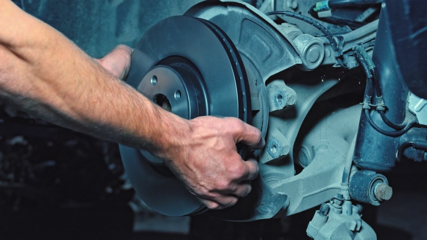 A car mechanic changing the disc brakes,
