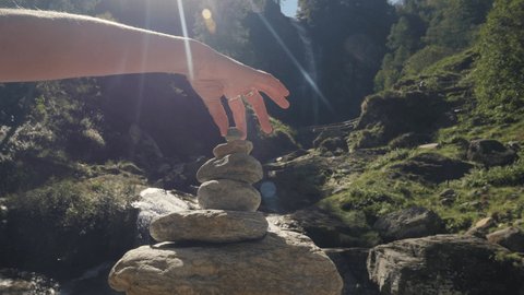Female's hand  staking rocks in nature