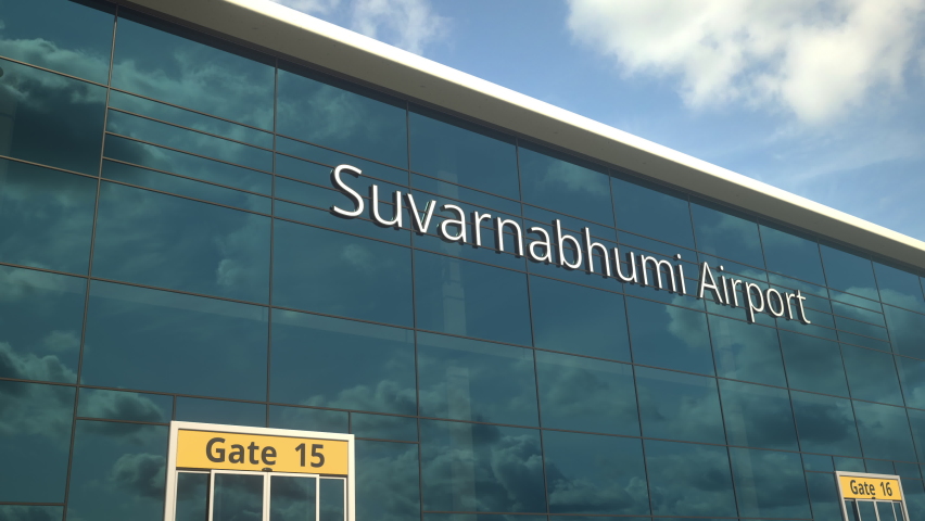 Landing airplane reflects in the modern windows with Suvarnabhumi Airport text