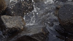 Video of waves hitting stones