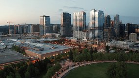 Cinematic 4K drone night rise and reveal clip of the city center of Bellevue, Downtown Park, Bellevue Square, illuminated skyscrapers, tall office and apartment buildings during blue hour after sunset