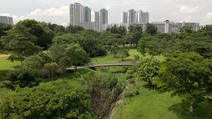 Bishan-Ang Mo Kio Park - Footbridge At Bishan Park With High-rise Buildings In The Distance In Singapore. - aerial | Shutterstock HD Video #1074188141
