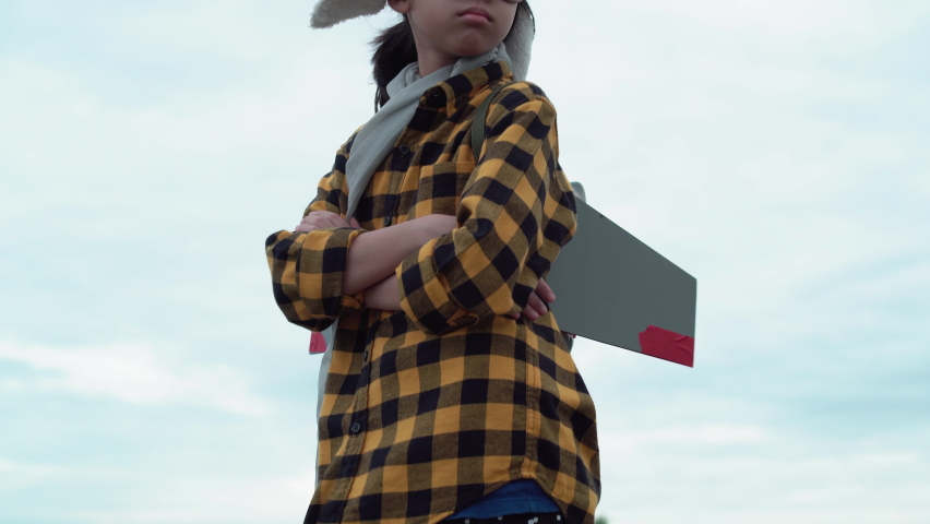 Asian child girl playing with toy rocket and standing with arms crossed, Happy kid playing outdoors