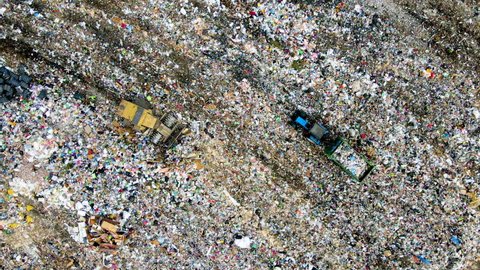 Landfill Dozer during working rubbish at garbage. Waste conservation. Trash disposal on rubbish dump. Arial view of landfill with plastic bags and food waste. Bulldozer on cleaning garbage. Trash
