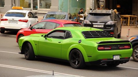 Kiev, Ukraine - June 12, 2021: Bright green American muscle car Dodge Challenger in the city